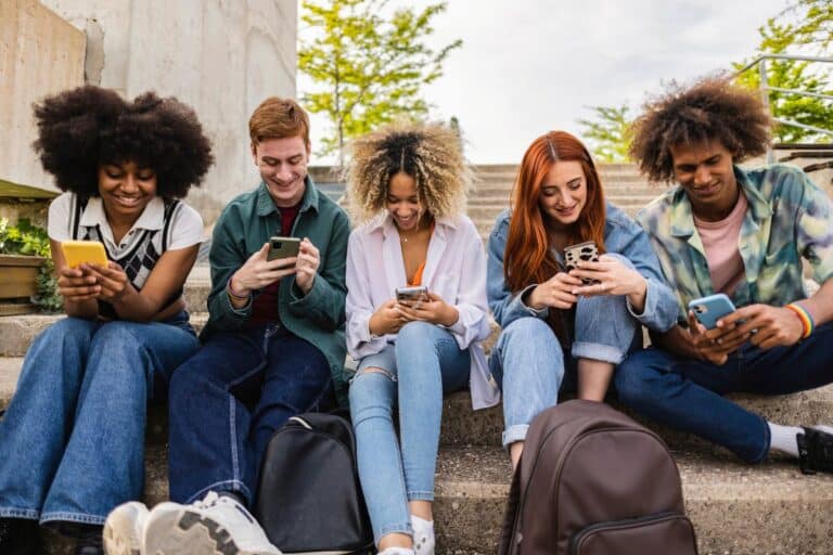 jeunes qui sont sur leur portable pour illustrer l'article "Définition des Réseaux sociaux"
