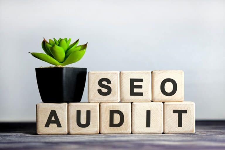 Mot SEO AUDIT sur des cubes de bois style scrable, pour illustrer l'article "SEO Manager : métier clé du Digital"