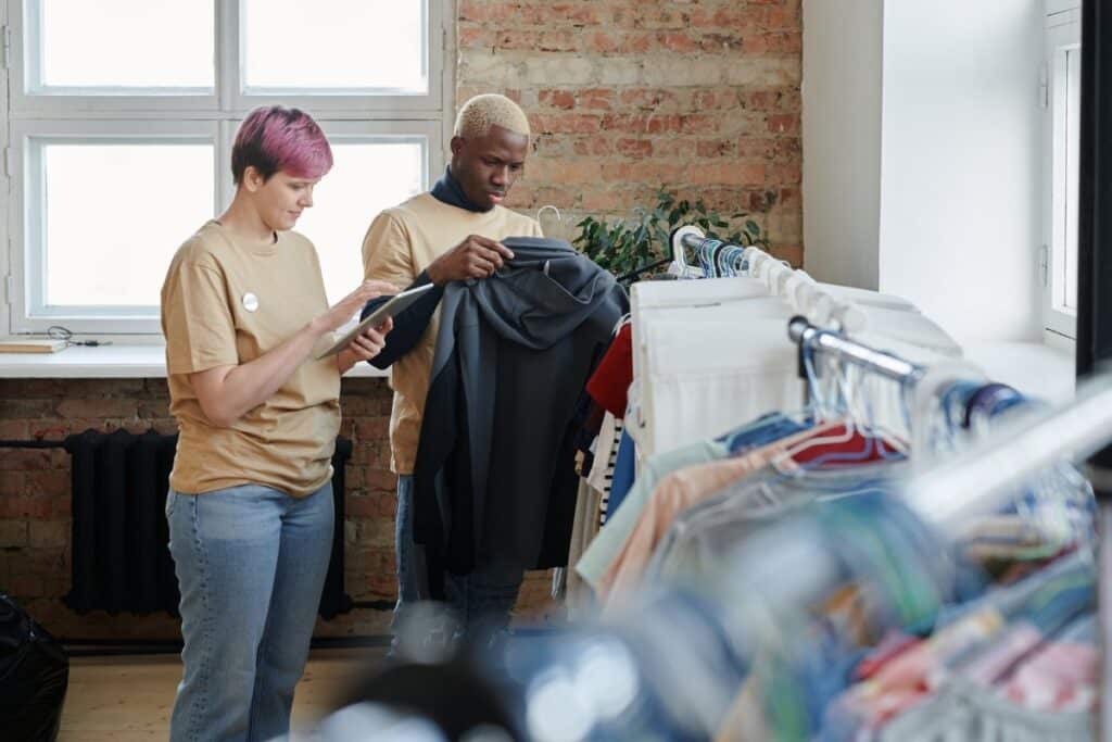 2 personnes qui regardent des vetement de seconde main à vendre sur Vinted